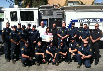 Supervisor Couch, Fire Chief Marshall, and Kern County Fire Fighters, present the Mountain Communities Chamber of Commerce Executive Director Rachel Unell with a re-purposed conference table made from a fire hazard tree